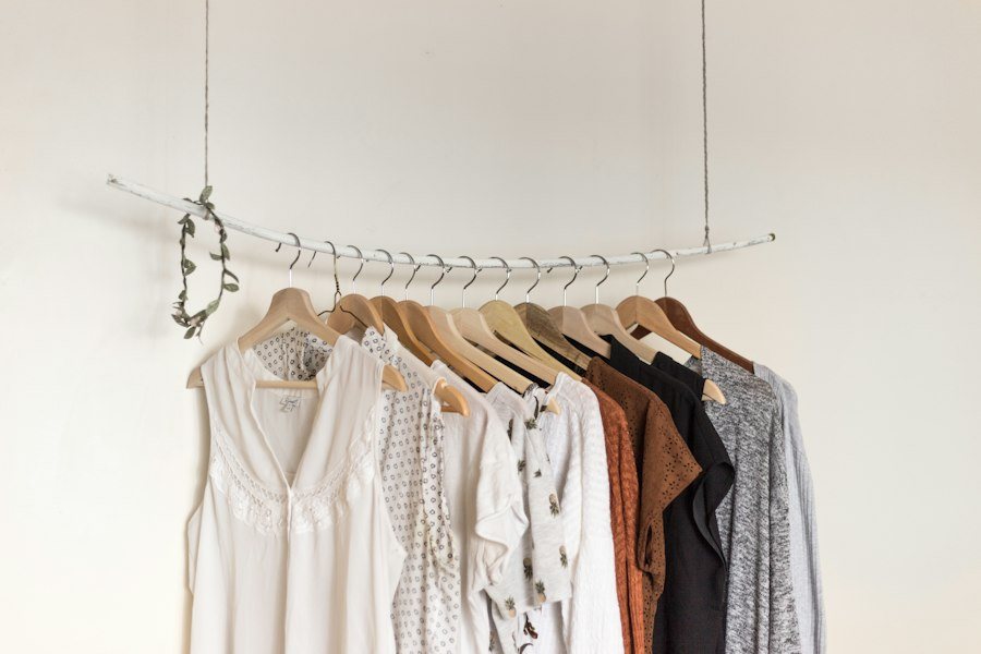 White garment rail with blouses, knits and shirts hanging in neutral tones